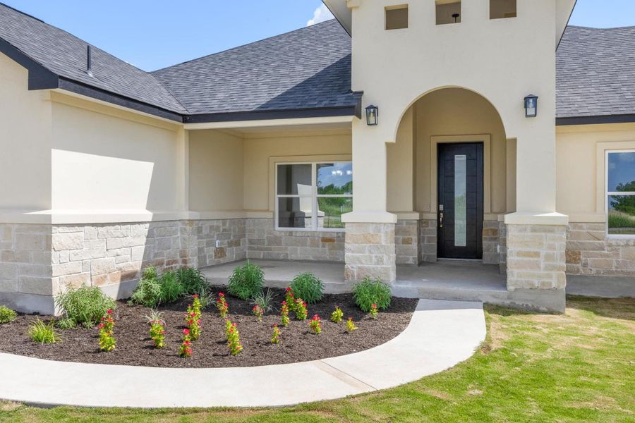 Entrance to property featuring roof with shingles, stone siding, stucco siding, and covered porch Entrance to property featuring roof with shingles, stone siding, stucco siding, and covered porch