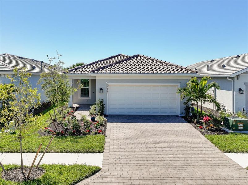 Front exterior of a new home in BeachWalk by Manasota Key, Englewood, FL, highlighting curb appeal (Image 25).