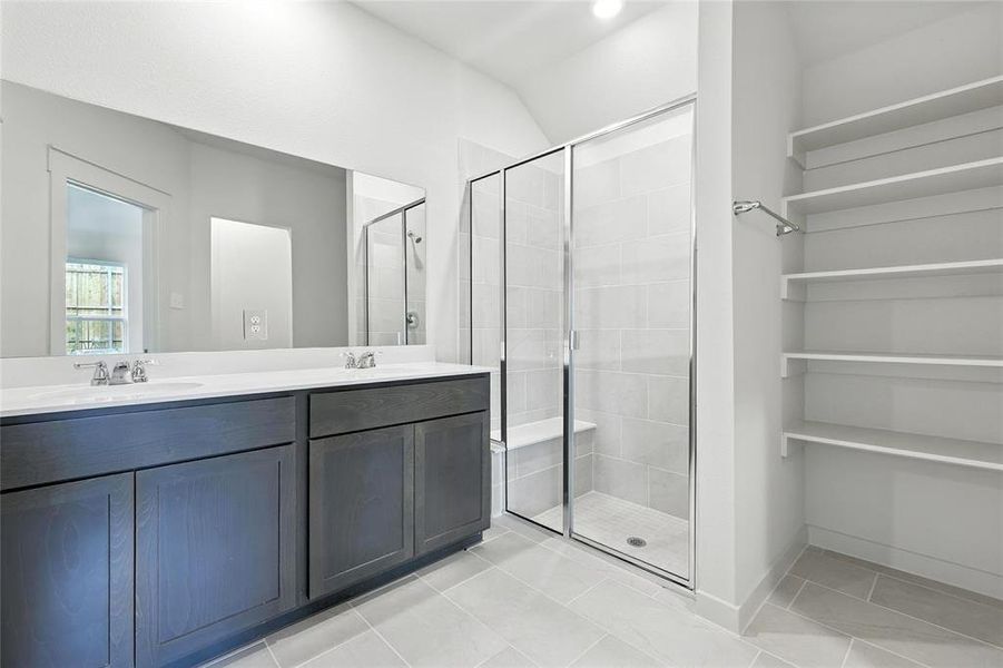 Bathroom with a stall shower and double vanity