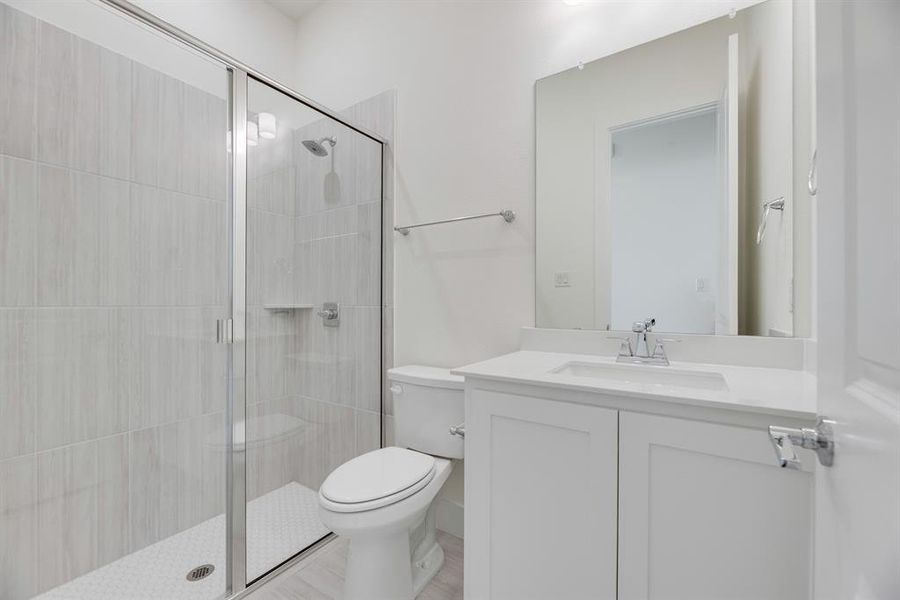 Full bathroom featuring a shower stall and vanity