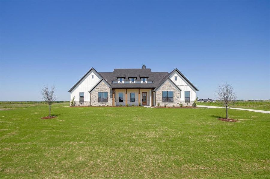 Modern inspired farmhouse with roof with shingles, a chimney, board and batten siding, stone siding, and a front lawn Modern inspired farmhouse with roof with shingles, a chimney, board and batten siding, stone siding, and a front lawn