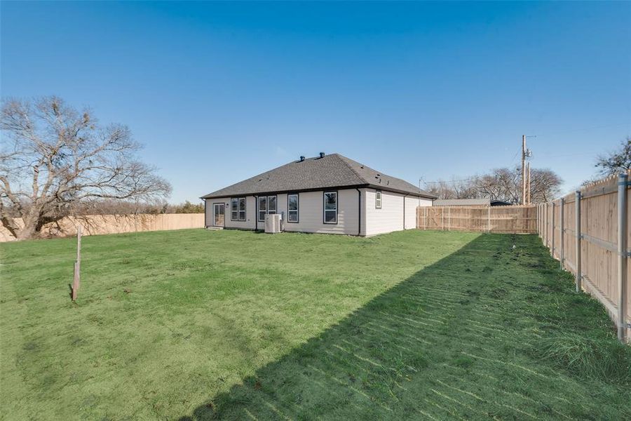 Rear view of property with a lawn