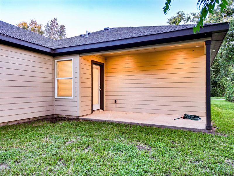 Rear view of property with a lawn, a patio, and a shingled roof Rear view of property with a lawn, a patio, and a shingled roof