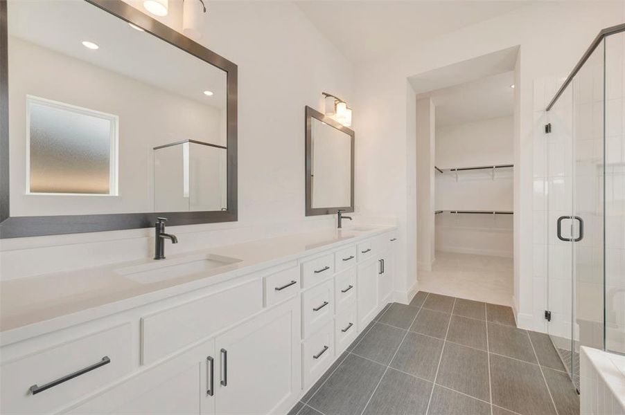 Contemporary bathroom featuring a double vanity with white cabinetry, matte black hardware, and an expansive countertop