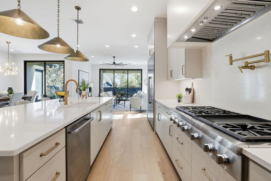 Kitchen with light wood finished floors, stainless steel appliances, open floor plan, and a spacious island