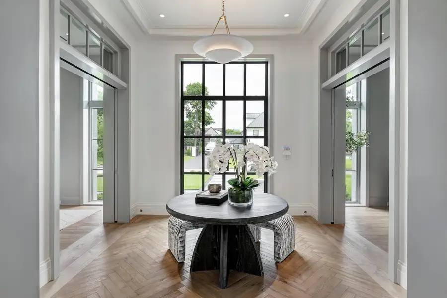 BellaVista steel double front doors bring light in and transom windows elevate and connect the living areas.