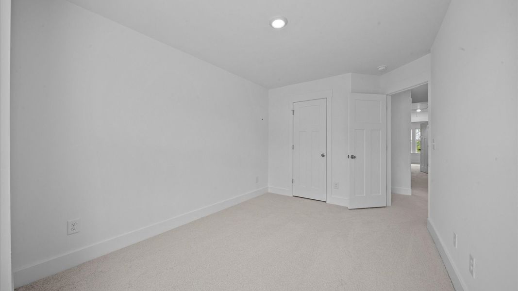 Bedroom with plush carpet and walk-in closet in two story townhome at Ransdell Pointe by DRB Homes in Spartanburg, SC