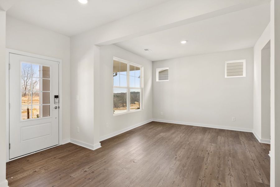 A room with a wood floor and windows. A room with a wood floor and windows.
