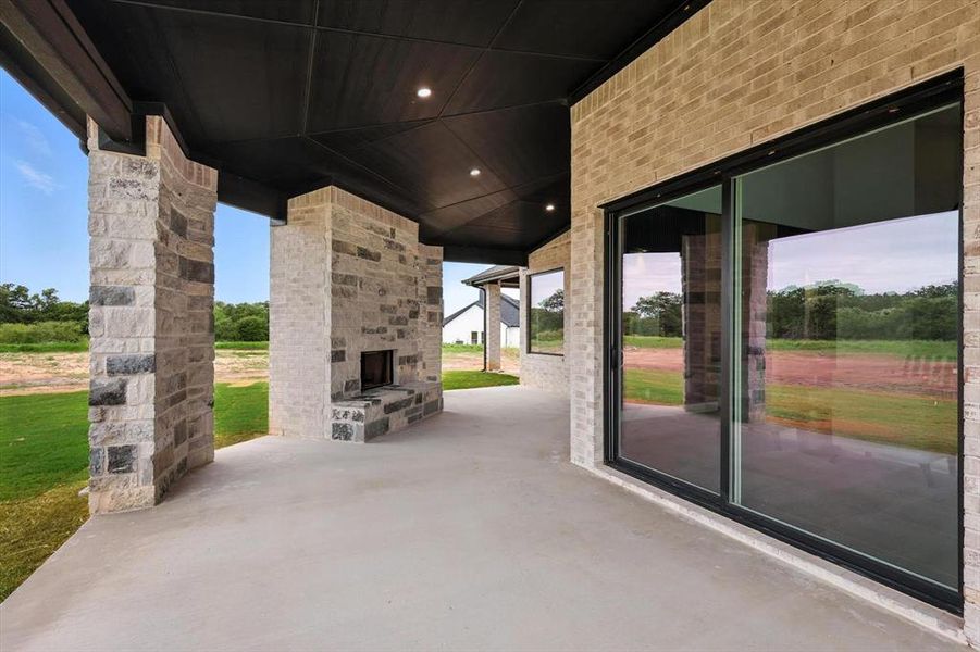 View of patio with an outdoor stone fireplace