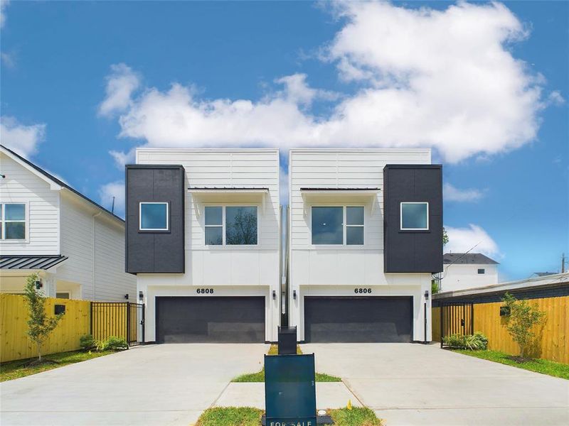 Modern single family homes with sleek design, featuring massive garages and a private driveway.