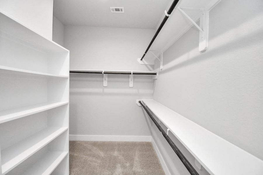 Walk-in closet that epitomizes luxury and practicality. This generously sized space features built-in shelving, offering abundant room for impeccable organization. High ceilings and recessed lighting create a bright and welcoming ambiance. Walk-in closet that epitomizes luxury and practicality. This generously sized space features built-in shelving, offering abundant room for impeccable organization. High ceilings and recessed lighting create a bright and welcoming ambiance.