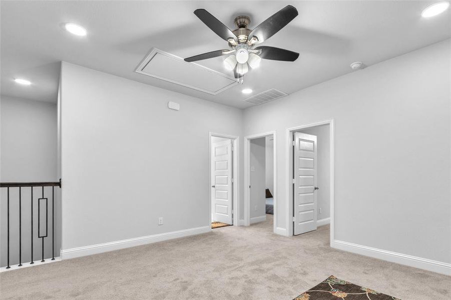 Empty room with recessed lighting, light colored carpet, visible vents, baseboards, and attic access