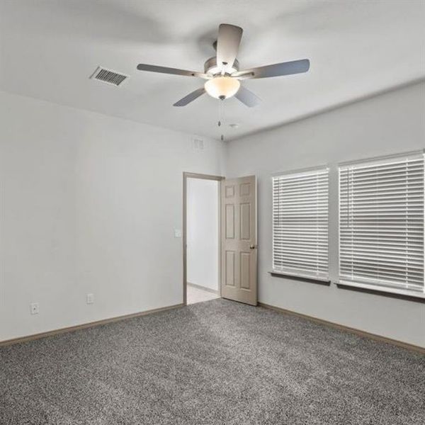 Three of three spacious secondary bedrooms featuring a lofty ceiling, large windows and elegant fan with lighting fixture. **This image is from another Saratoga Home with similar floor plan - Myrtle Floorplan.**