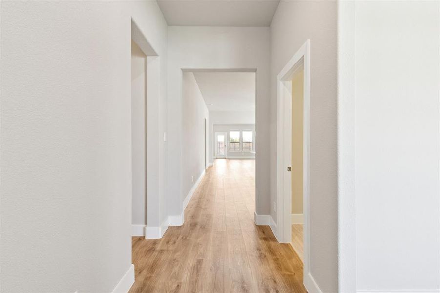Hall with light wood-style floors and baseboards