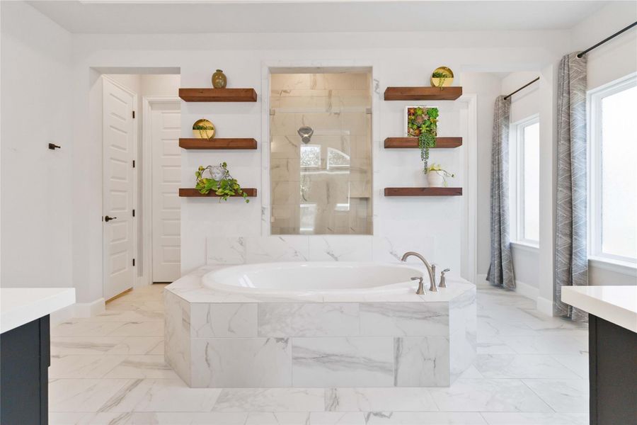 Full bath featuring vanity, a garden tub, and light marble finish floors Full bath featuring vanity, a garden tub, and light marble finish floors