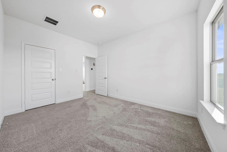 Unfurnished bedroom with carpet and multiple windows