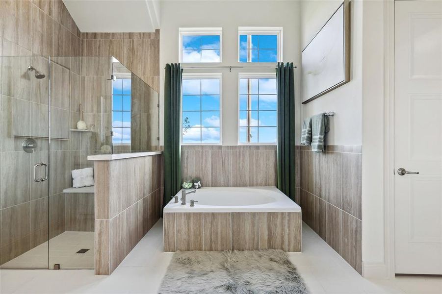 Bathroom featuring wood-look tile accents, a built-in soaking tub, and a glass-enclosed shower with a built-in bench