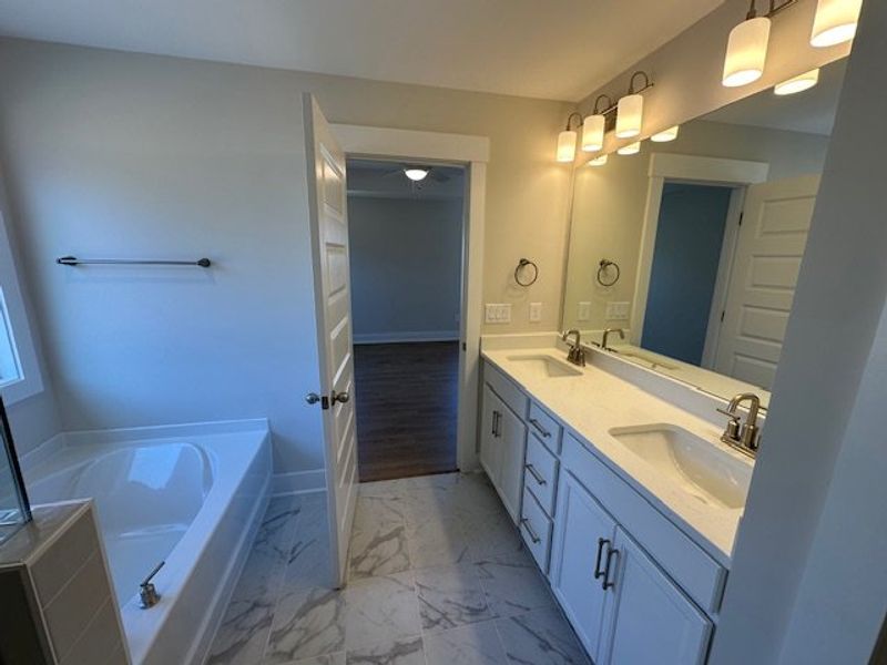 This bathroom features a double vanity and soaking