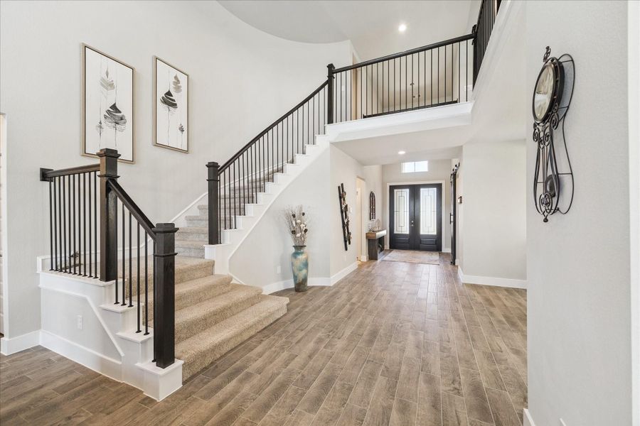 Spacious two-story foyer with tile flooring, soaring ceilings, and an elegant wrought-iron staircase. Spacious two-story foyer with tile flooring, soaring ceilings, and an elegant wrought-iron staircase.