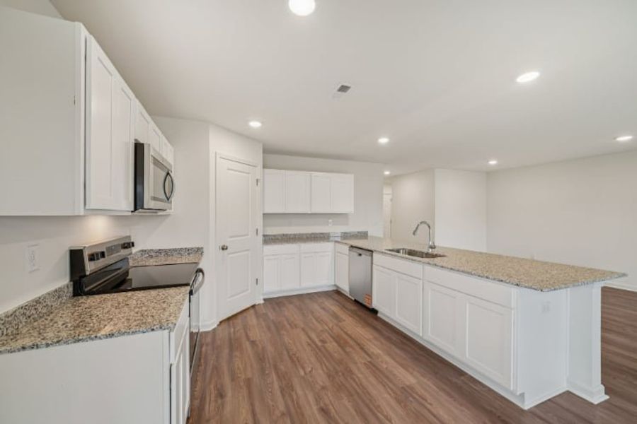 A kitchen with white cabinets.