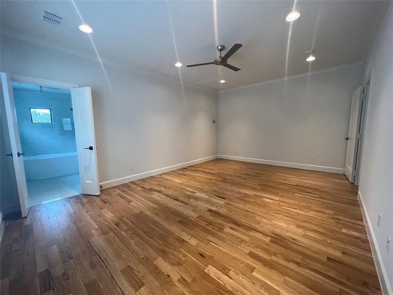 Empty room with hardwood / wood-style floors, ceiling fan, and ornamental molding