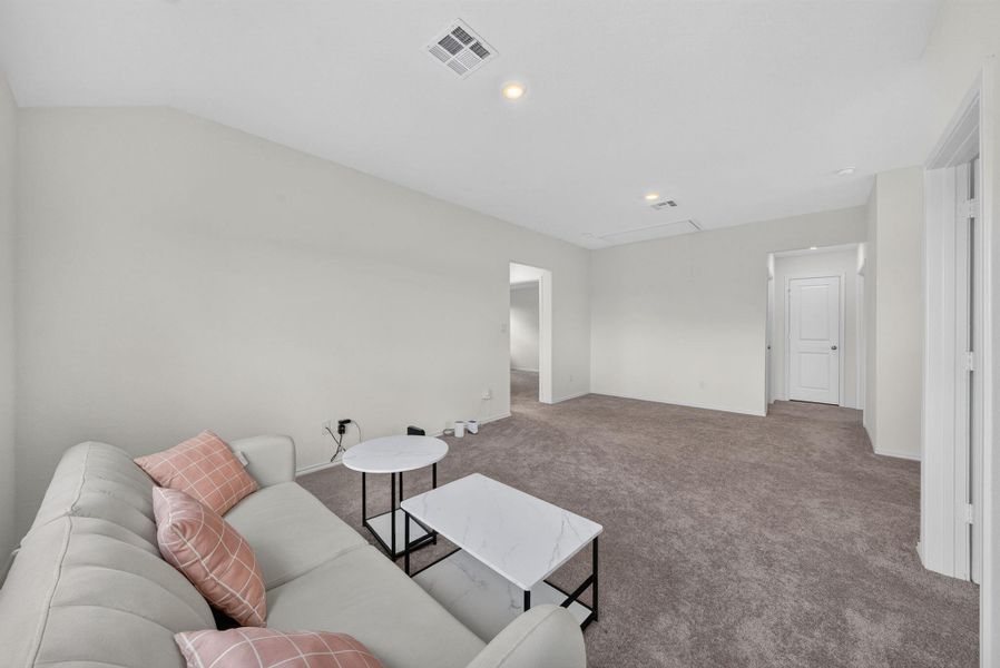 A spacious secondary living area features soft carpeting and ample wall space, ideal for relaxation or entertainment. A spacious secondary living area features soft carpeting and ample wall space, ideal for relaxation or entertainment.