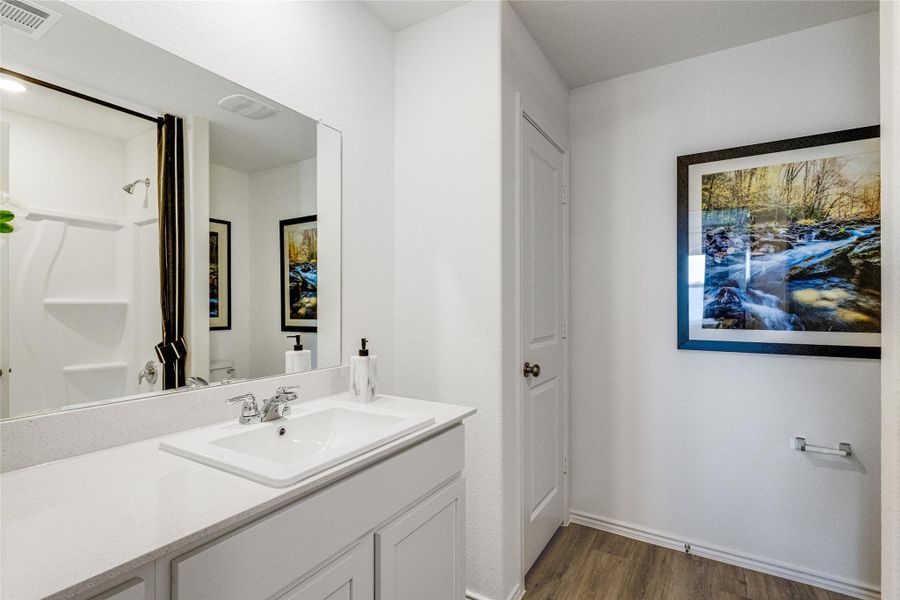 Full bath featuring dark wood finished floors, vanity, and a shower Full bath featuring dark wood finished floors, vanity, and a shower