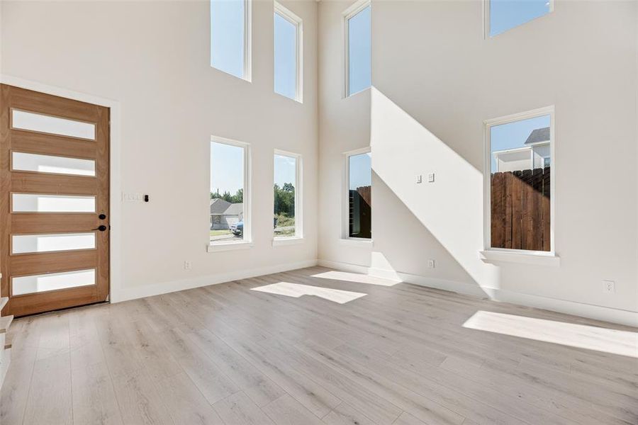 Entrance foyer featuring light wood-style floors and a towering ceiling Entrance foyer featuring light wood-style floors and a towering ceiling