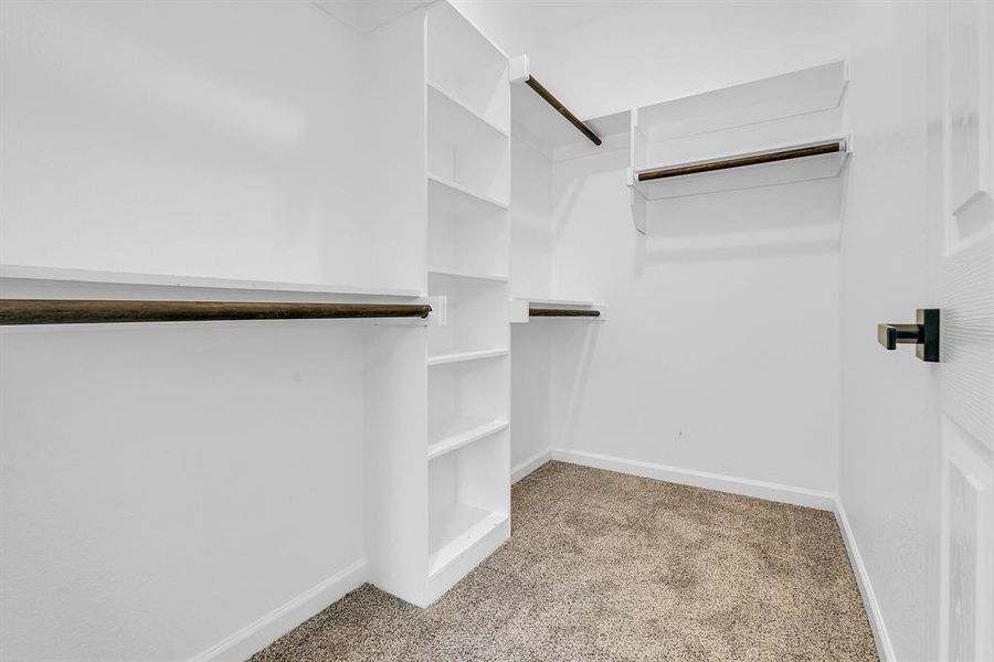 Walk in closet with light carpet