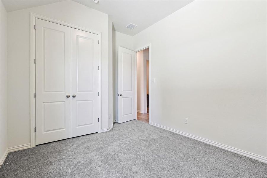 Unfurnished bedroom with light colored carpet and a closet