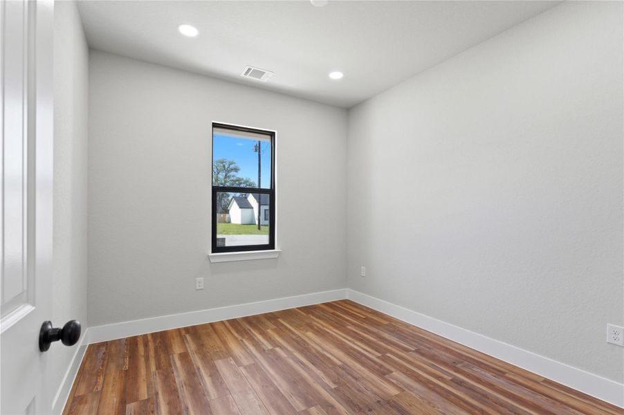 Unfurnished room with wood finished floors and recessed lighting