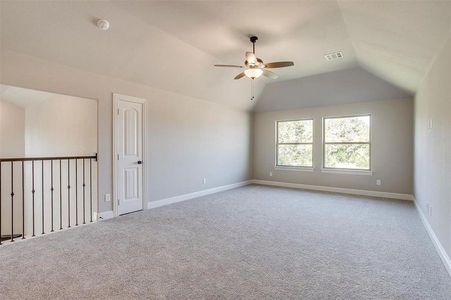 Unfurnished room with lofted ceiling, light colored carpet, and ceiling fan