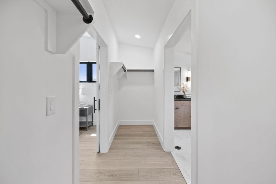 Hall with light wood-style flooring, recessed lighting, and a barn door