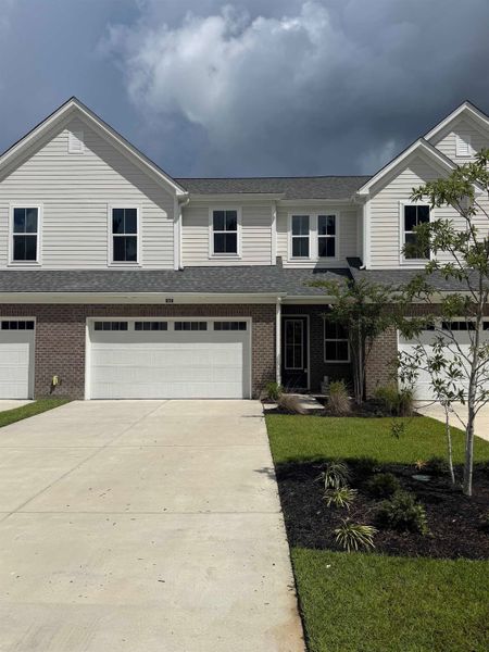 Front exterior of a new home in Long Bay Golf Club, Longs, SC, highlighting curb appeal (Image 2). Front exterior of a new home in Long Bay Golf Club, Longs, SC, highlighting curb appeal (Image 2).