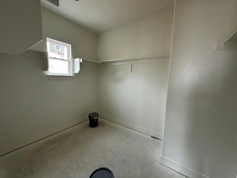 Laundry area with baseboards and unfinished concrete floors