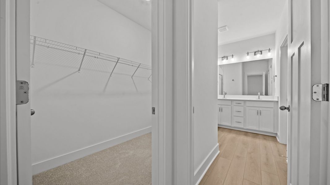 Memorable mornings begin in this elegant primary bathroom with walk-in shower and double vanity