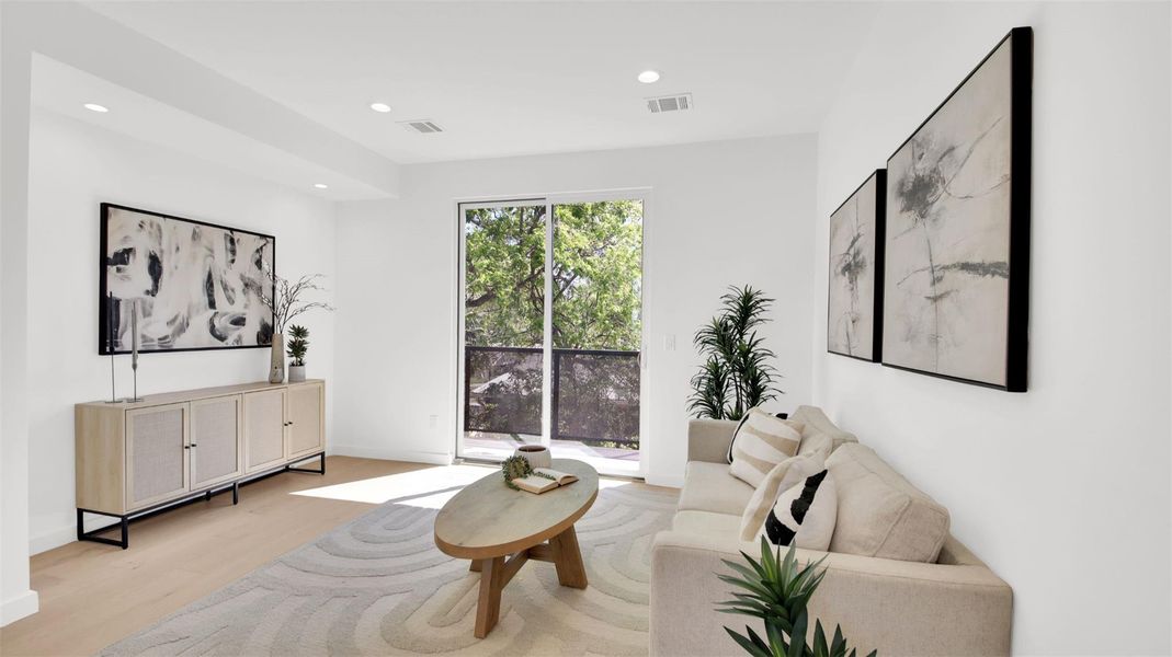 Living room with light wood-type flooring and recessed lighting with access to balcony