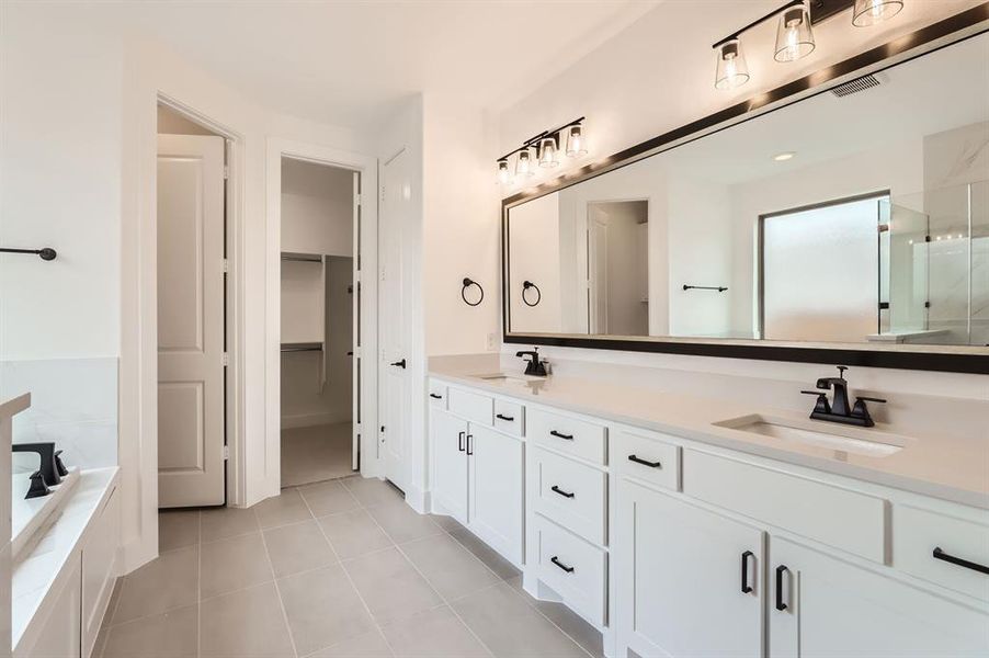 Bathroom with vanity, tile patterned floors, and plus walk in shower