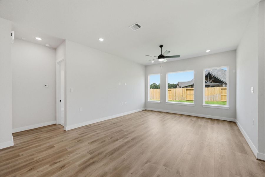 Expansive family room with multiple windows, recessed lighting, and an open layout designed for comfortable everyday living and entertaining.
