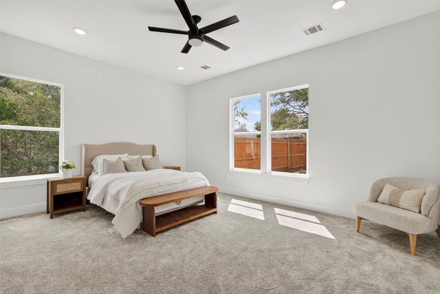 Carpeted bedroom with a ceiling fan and recessed lighting