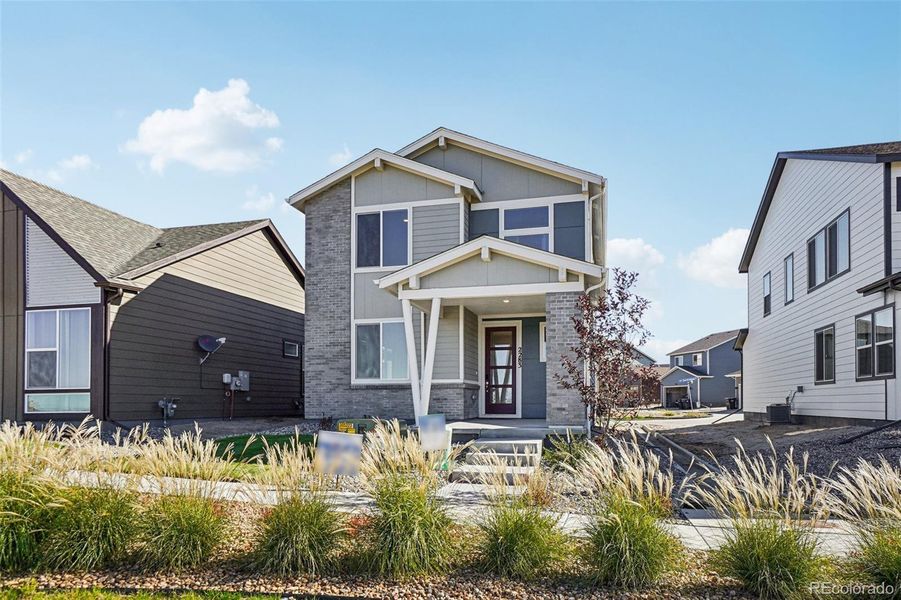 Front exterior of a new home in Parkway at Prairie Center Village, Brighton, CO, highlighting curb appeal (Image 1).