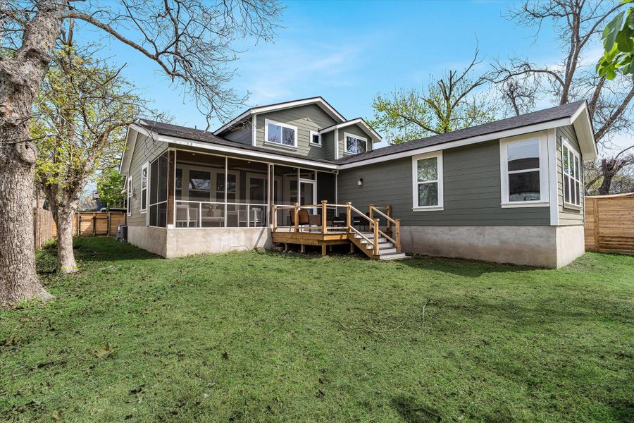 The property features a screened-in porch and an outdoor deck with steps descending to a grassy yard The property features a screened-in porch and an outdoor deck with steps descending to a grassy yard