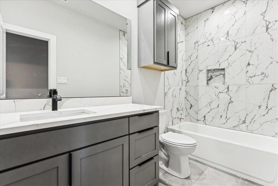 Full bathroom featuring vanity, toilet, and tiled shower / bath