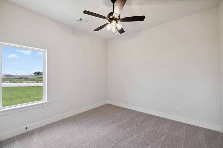 Carpeted empty room with ceiling fan