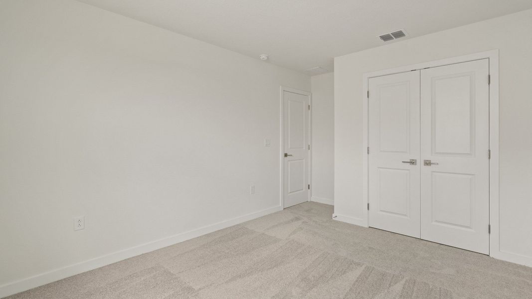 Spacious third bedroom with generous closet space and neutral tones—ideal for guests, kids, or a home office