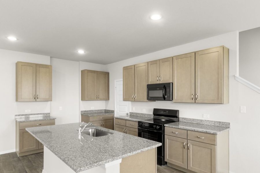 Image of a kitchen with light brown cabinets, granite countertops and black kitchen appliances