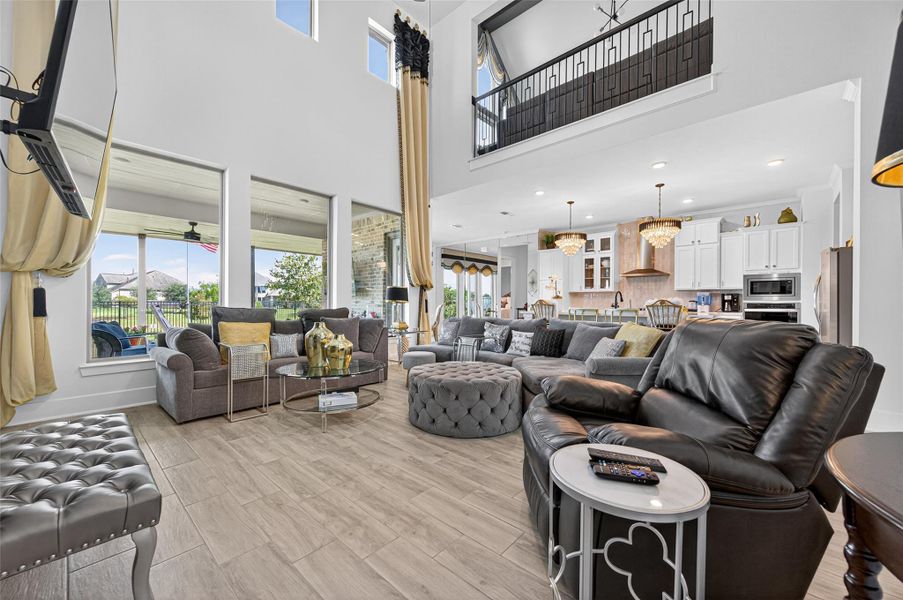 This spacious living area features high ceilings, large windows for natural light, and an open layout connecting to a modern kitchen. Cozy seating and elegant fixtures add to the inviting atmosphere, while the view outside enhances the appeal. This spacious living area features high ceilings, large windows for natural light, and an open layout connecting to a modern kitchen. Cozy seating and elegant fixtures add to the inviting atmosphere, while the view outside enhances the appeal.