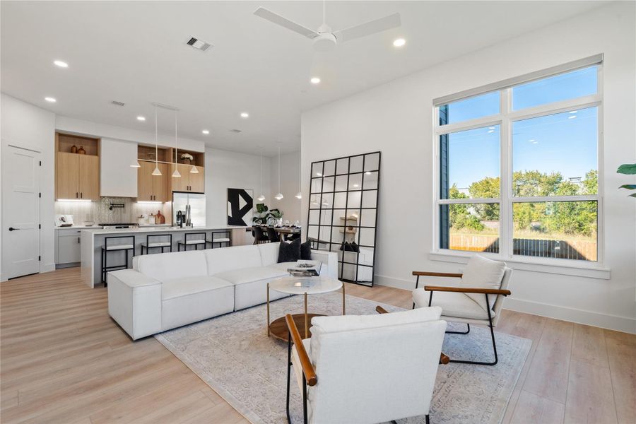 An expansive open-concept layout defined by ceiling height, clean sightlines, and abundant natural light—where living, dining, and kitchen spaces connect seamlessly through intentional design and proportion.