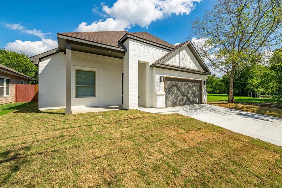 View of front facade featuring a garage and a front yard