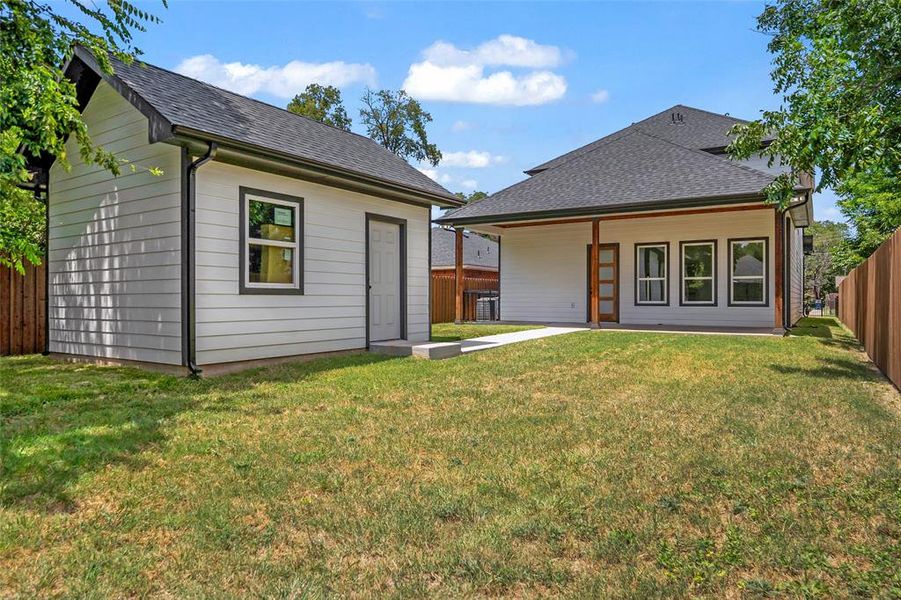 Back of property with a nice fenced backyard, an outdoor structure, and a patio Back of property with a nice fenced backyard, an outdoor structure, and a patio